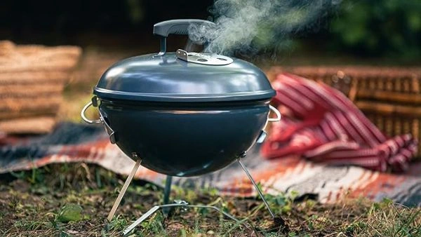 Gratar Smokey Joe albastru cu patura si cos de picnic pe fundal